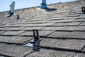 Residential asphalt shingle roof with metal anchors installed for the installation of a solar panel rail and racking