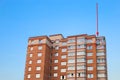 Residential building against the sky. Building. New buildings. Red brick. Disfigurement of the building with air conditioning. The