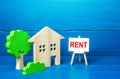 Residential building figurine and easel rent sign. Search for rental housing. Real estate realtor services. Legal procedure Royalty Free Stock Photo