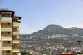 Residential building in front of a pine-covered mountain, Alanya, Turkey, April 2021 Royalty Free Stock Photo