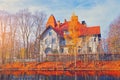 Residential building on river in autumn park. Beautiful vintage house in morning sunny sky. Yellow fall tree leaves on a Royalty Free Stock Photo