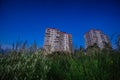 Residential buildings against a dark blue evening sky, bottom view. Typical housing that protrude above the green grass. Royalty Free Stock Photo