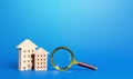 Residential buildings and magnifying glass. Search for real estate to buy. Long-term and short-term rental of apartments and Royalty Free Stock Photo