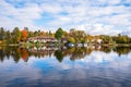 Residential buinmgs among colourful autumn trees on the shore of a lake