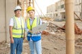 Residential construction workers standing at construction site talking on housing development project using laptop notebook. Royalty Free Stock Photo
