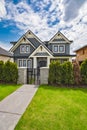 Residential family house with concrete pathway over green lawn on the front yard