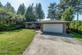 Residential home from garage side exterior driveway concrete green grass Forest Blue sky real estate moderate Royalty Free Stock Photo