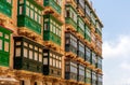 Residential house facade with traditional Maltese green wooden balconies in Valletta, Malta Royalty Free Stock Photo