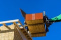 Residential house under construction worker is covering the wooden frame with plywood using hydraulic hammer Royalty Free Stock Photo