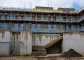 Residential housing development construction site with retaining wall unfinished concrete stairs leading to scaffold erected