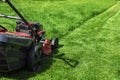 Lawn mower cutting green grass Royalty Free Stock Photo