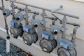 Residential natural gas meter measuring gas consumption and pressure regulator. Row of residential natural gas meters