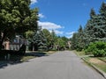 Residential street of large traditional detached houses, lined with trees