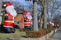 Residential street with a proliferation of giant inflatable Santa Claus dolls