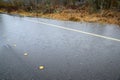 Residential street with water flooding woodland and roadway, still raining, stormy day