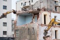 Residential three story building demolition with hydraulic excavators Royalty Free Stock Photo