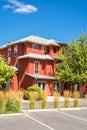 Residential townhouse with parking lots in front on blue sky background