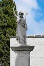 Resigned and grieving statue on the grave of a dead person as a sign of remembrance and respect for the deceased in the