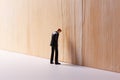 Resilience in Adversity Miniature Businessman Confronting a Wall of Despair, Embodying the Business Concept of Overcoming Failure Royalty Free Stock Photo