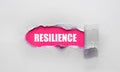 Resilience word concept written under torn paper