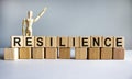 `Resilience` written on wood blocks. Business concept. Wooden model of human. Copy space. Beautiful white background