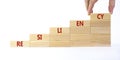 Resiliency symbol. Wooden blocks with word `resiliency` stacking as step stair on beautiful white background, copy space.