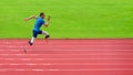 A resilient Asian paralympic athlete, equipped with prosthetic running blades, can be seen intently training on an athletic track