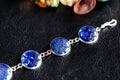 Resin bracelet with blue glitters on a dark surface close-up