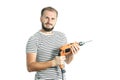 A resolute bearded man holds a power tool - electric drill in his hands. Isolated on white background Royalty Free Stock Photo