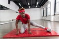 Resolute dark-skinned short-haired man making exercises in empty studio