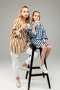 Resolute little girl sitting on tall chair and tasting milk