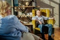 Resolute short-haired man in blue jeans sitting in front of his wife