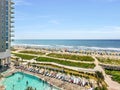 a resort featuring a sparkling blue ocean, white sand beach, and a resort pool Royalty Free Stock Photo