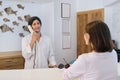 Resort hotel front desk, woman guest talking to man working at reception Royalty Free Stock Photo