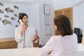 Resort hotel front desk, woman guest talking to man working at reception Royalty Free Stock Photo