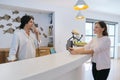 Resort hotel front desk, woman guest talking to man working at reception Royalty Free Stock Photo