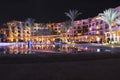 Resort hotel is reflected in water of pool at night. Holidays at Egyptian resort. Lights of evening hotel are reflected in pool Royalty Free Stock Photo