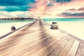 Resort in Maldives at sunset. Water villas along wooden jetty Royalty Free Stock Photo