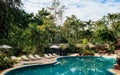 Resort style beach daybeds and umbrellas by swiming pool in tropical garden, Kanchanaburi, Thailand Royalty Free Stock Photo