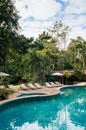 Resort style beach daybeds and umbrellas by swiming pool in tropical garden, Kanchanaburi, Thailand Royalty Free Stock Photo