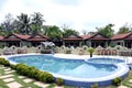 RESORT SWIMMING POOL , PALM TREES , FIVE HOUSES .