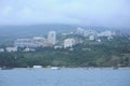 Resort town Gurzuf, buildings beach mountains plunged in a fog cloudy sky, view from the sea. Southern coast of the