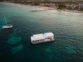 Resort town on the seashore. White pleasure boat in the sea. Houses and tropical plants on the shore. Resort, vacation, sea travel Royalty Free Stock Photo