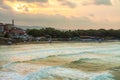 Resort town of Sozopol in Bulgaria at sunset on the Black Sea coast. Sea waves with white foam roll on the sandy part of the beach