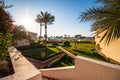 Resort view with palms, garden and blue sky in the morning