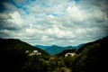 Resort village in mountain valley against the blue sky with clouds, summer landscape Royalty Free Stock Photo