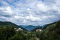 Resort village in mountain valley against the blue sky with clouds, summer landscape Royalty Free Stock Photo