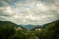 Resort village in mountain valley against the blue sky with clouds, summer landscape Royalty Free Stock Photo