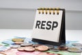 RESP letters on notebook with coins and bills on a clear background Royalty Free Stock Photo