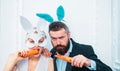 Respect traditions. Happy easter day. Bunny rabbit man and girl eat carrot. Cute bunny wear formal suit tuxedo Royalty Free Stock Photo